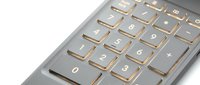 Close-up of modern laptop keyboard with illuminated keys and metallic finish, suitable for technology and computing concepts.