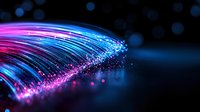 Glowing optical fiber strands emit pink and blue light particles against dark background, creating dynamic motion effect with bokeh and sparkles. For technology designs.