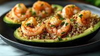 Grilled shrimp served on zucchini boats filled with quinoa and fresh herbs, garnished with parsley. Healthy low-carb Mediterranean appetizer on dark plate.