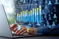 Business professional analyzing financial data on laptop with holographic charts and graphs displaying growth metrics and analytics dashboard interface.