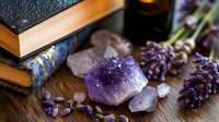 Amethyst crystals with lavender flowers and old books on wooden surface for spiritual healing meditation and relaxation practices.