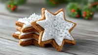Festive star-shaped gingerbread cookies with white icing and silver sugar pearls on wooden table, perfect for holiday season celebrations.