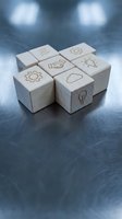 Wooden cubes with business icons including lightbulb, gears, handshake and cloud symbols on dark surface representing innovation and teamwork concepts.