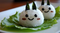 Cute rice balls shaped as smiling characters with seaweed details and decorative elements served on fresh lettuce leaves, creative Asian food styling for children.