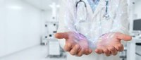 Healthcare professional displaying holographic love text symbol above cupped hands in modern medical facility representing compassionate patient care.