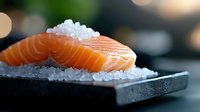 Fresh raw salmon sushi slice on crushed ice crystals against dark background with soft bokeh lights, close-up view showing delicate texture and vibrant color.