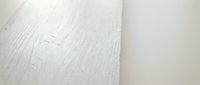 White wooden floor with natural grain texture and subtle shadows, suitable for interior design, home decor, and architectural backgrounds.