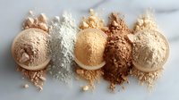 Makeup foundation powder swatches in different skin tone shades from light to dark arranged in line on white background, cosmetic texture close up.