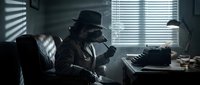 Noir detective in fedora and trench coat sitting at desk with typewriter, smoking cigarette in dimly lit office with venetian blind shadows, vintage crime scene atmosphere.