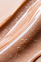 Liquid foundation or concealer texture with bubbles and swirls in nude beige tones, macro cosmetic background for beauty and skincare marketing.