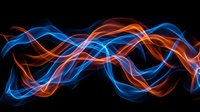 Abstract flowing energy waves in vibrant blue and orange neon colors against dark background. Glowing light trails create dynamic motion effect for modern design projects.