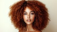 Young African American woman with voluminous curly auburn hair against neutral background, showcasing natural beauty and confidence for fashion or beauty campaigns.
