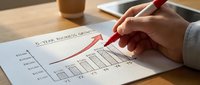 Business professional analyzing upward trending graph with red pen on financial chart showing growth statistics and performance metrics on desk.