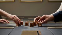 Business professionals collaborating to arrange wooden blocks spelling CORE on conference table during strategic planning meeting.