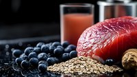Young adult female, Caucasian ethnicity, nutritionist or health professional, holding fresh grapefruit with blueberries and oats for healthy diet promotion and wellness content.