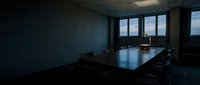 Modern minimalist conference room with sleek black table, ergonomic chairs, and floor-to-ceiling windows overlooking cityscape. Corporate meeting space for business presentations and team collaboration.