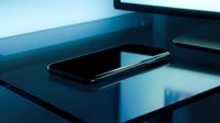 Smartphone lying on a dark glossy desk in blue ambient light, modern tech workspace with sleek minimalist design for business and digital concepts.