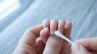 Woman applying cuticle oil to fingernails during manicure routine. Professional nail care and beauty treatment for healthy hands and nails at home.