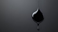 Dramatic black liquid drop forming on spoon against dark background, creating sleek minimalist composition with glossy reflection and falling droplet.