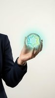 Businessman holding glowing holographic teamwork network symbol in palm representing collaboration and partnership in modern business environment.