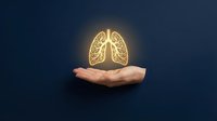 Glowing lungs held in open palm against dark background, representing respiratory health, medical care, and wellness awareness for healthcare and insurance concepts.