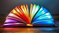 Open book with vibrant rainbow colored pages spreading in fan formation creating magical light spectrum effect on wooden surface for education concepts.