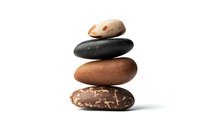 Stack of four natural stones in brown and black tones balanced on white background, zen-like composition showing harmony and stability. Isolated photo for wellness designs.