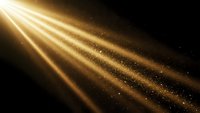 Golden light rays streaming through darkness with sparkling particles creating dramatic illumination effect for backgrounds and design projects.