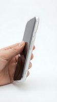 Caucasian hand holding transparent smartphone case with device inside, isolated on white background for product mockup and design use.