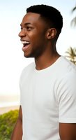 Young African American man in white t-shirt smiling outdoors with tropical foliage background, expressing joy and positivity for lifestyle and wellness marketing campaigns.