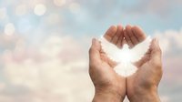 Hands holding glowing light against soft sky background, symbolizing hope, spirituality, protection and positive energy for wellness and inspirational concepts.