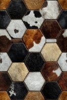 Hexagonal patchwork pattern made from natural cowhide leather pieces in brown, black, white and tan colors with visible stitching creating rustic texture.