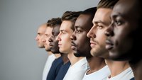 Diverse group of men in profile view showing multicultural unity and teamwork in professional business environment with neutral background.