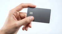 Hand holding modern black credit card with chip technology for secure financial transactions and digital payments on white background.