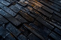 Dark wet cobblestone pavement with diagonal pattern and golden light reflection creates moody urban atmosphere, suitable for background designs.