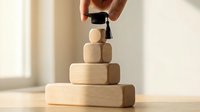 Hand placing graduation cap on wooden block pyramid symbolizing educational achievement and academic success journey.