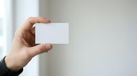 Man holding blank white business card in hand against neutral background, suitable for branding and corporate identity mockups.