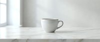 White ceramic coffee cup on marble table in bright minimalist kitchen interior with natural window light for morning beverage and home decor concepts.