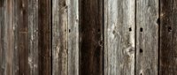 Weathered wooden fence planks with natural grain patterns and rustic texture for construction and home improvement projects.