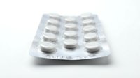 Blister pack of white pharmaceutical tablets and capsules isolated on white background, ready for medical and healthcare design use.