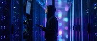 IT technician working in modern data center server room with blue lighting and digital network connections for technology infrastructure maintenance.