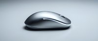 Sleek silver wireless mouse with ergonomic curved design on neutral background, suitable for tech product marketing and computer accessory websites.