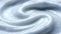 Smooth white cream swirl with flowing texture creating elegant spiral pattern for skincare and cosmetic product backgrounds.