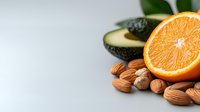 Fresh orange half, almonds, avocado and chickpeas on white background. Healthy fats and vitamin rich ingredients for nutritious eating and wellness lifestyle.