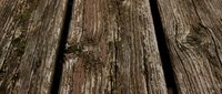 Weathered wooden planks with natural grain texture and rustic brown surface for construction and design projects.