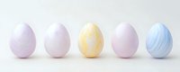 Pastel colored Easter eggs in row on white background, decorated with marble effect pattern. Minimal spring holiday composition for seasonal design.