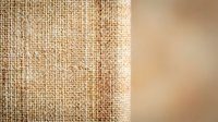 Natural burlap fabric texture with soft beige background for rustic design projects and organic material concepts.