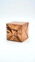 Handcrafted wooden cube with geometric faceted surface and natural wood grain texture isolated on white background for modern interior design.