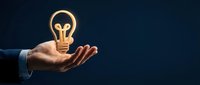 Businessman hand holding glowing light bulb symbol representing innovation, creativity, and bright business ideas for entrepreneurship and success concepts.