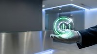 Businessman hand holding glowing green holographic house icon with circular arrows, representing sustainable real estate, smart home technology, and eco-friendly property investment solutions.